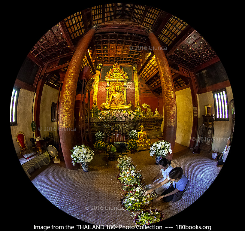 Image of Worshipers place offerings inside the viharn of Wat Ton Kwen