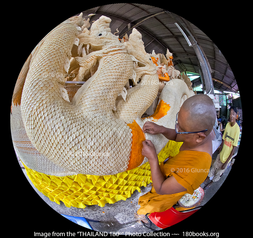 Image of a monk affixing molded beeswax shapes to a sculpture..