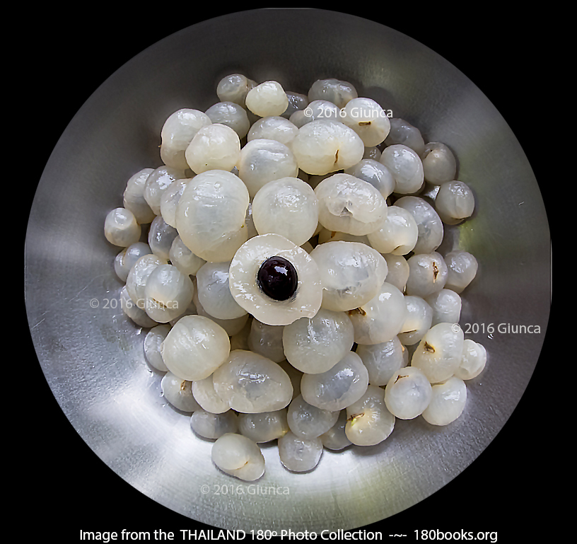 Image of Peeled longan fruit ~One sliced to show why they are called dragon eyes in China