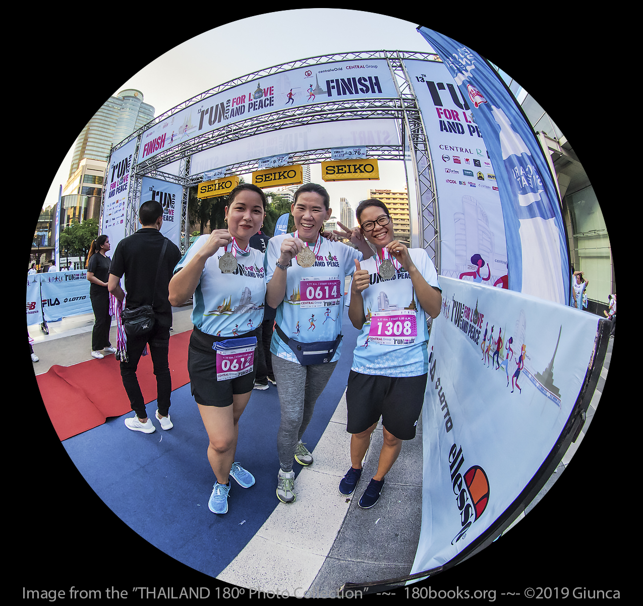 fisheye photo of Fon, P'Nong, and Ning at the finish